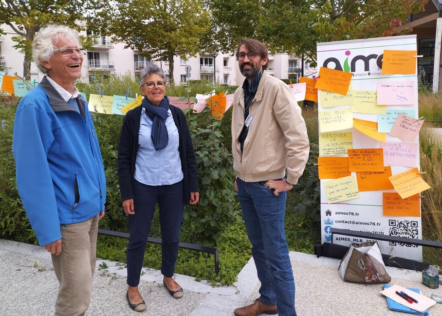 Photo d'un atelier porteur de paroles avec un panneau plein de propositions des citoyens et avec Jean-Luc, Isabelle et Vivien.